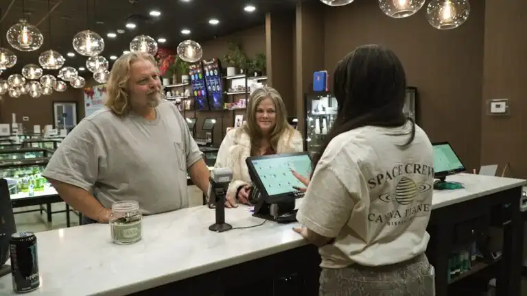 Customers interact with staff at a dispensary counter.